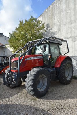 un tracteur rouge garé devant un bâtiment