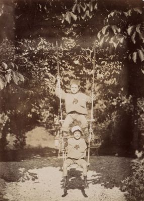 a vintage photo of a young boy on a swing