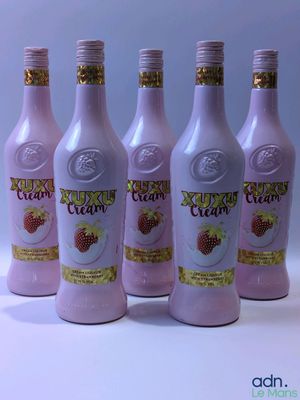 six bouteilles d'une délicieuse crème aux fraises posées sur un plan de travail blanc