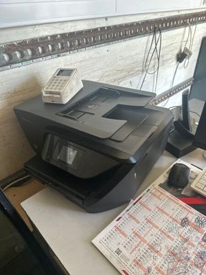 une imprimante posée sur un bureau à côté d'un téléphone portable