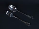 two spoons and a fork on a black surface
