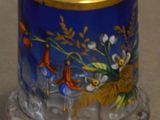 un vase bleu bordé d'or et orné de fleurs