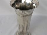 a silver vase that is sitting on a white table