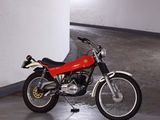 a red motorcycle parked in a parking garage next to a white wall