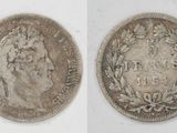 a close up of two silver coins on a white surface