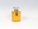 un vieux flacon de parfum posé sur une surface blanche