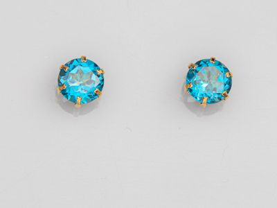 une paire de boucles d'oreilles à clous en cristal bleu sur fond blanc
