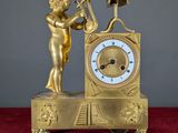 une horloge en or surmontée d'une statue