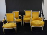 quatre chaises jaunes devant un fond noir dans une pièce