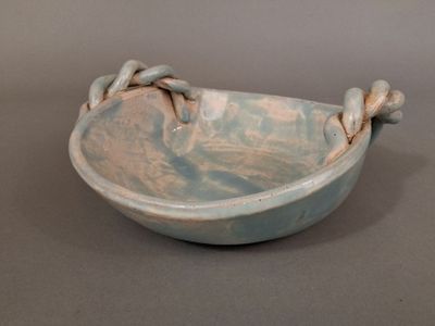 a blue bowl with a chain around it on a table