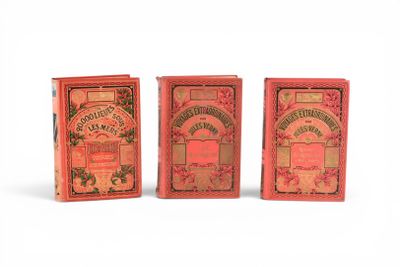 trois petits livres rouges sont alignés sur une surface blanche