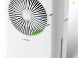 un purificateur d'air blanc et noir d'où sortent des feuilles vertes