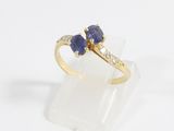 a close up of a gold ring with two blue sapphires