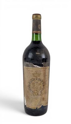 une vieille bouteille de vin posée sur une surface blanche
