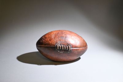 a brown leather football on a white surface