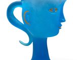 a blue glass vase with a face on it