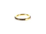 gros plan d'une bague en or sur fond blanc