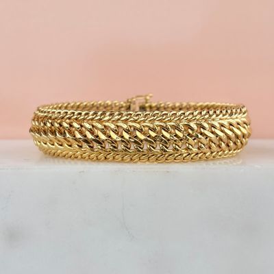 an image of a gold bracelet on a marble surface