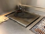 stainless steel counter top with a grill on top of it in a kitchen