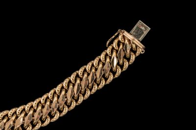 une image montrant un gros plan d'un bracelet en or sur fond noir