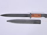 pair of two knives on a white surface one has a wooden handle and the other has a black handle