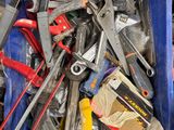 a blue bin full of tools sitting on the ground
