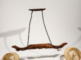 a wooden object hanging from a chain on the wall