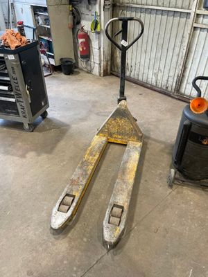 a forklift in a garage with other equipment in the background
