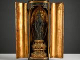 une statue dorée et noire représentant une femme dans une entrée