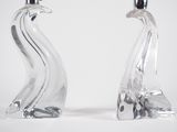 pair of clear glass swan candlesticks on a white background