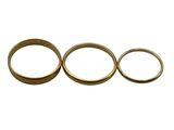 three gold wedding rings sitting side by side on a white surface