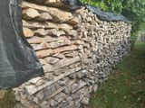 un gros tas de bois de chauffage empilé contre une clôture