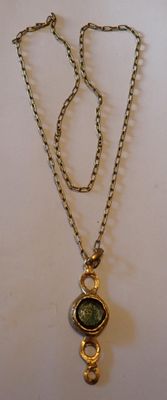 collier plaqué or avec un pendentif en pierre verte sur une chaîne