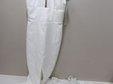une robe blanche suspendue à un cintre à côté d'un pantalon blanc