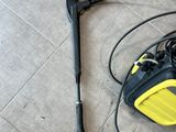 a yellow and black pressurer on the floor next to a black and yellow hose