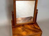a small mirror sitting on top of a wooden stand