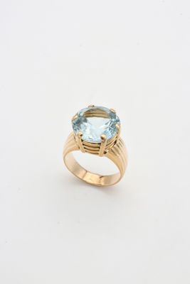 une bague en or sertie d'une topaze bleue au centre