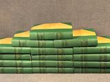 many green books stacked on top of each other