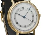 a close up of a gold wrist watch with roman numerals
