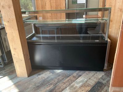 a glass display case with a black base in a room