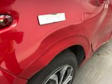 a close up of a red car with a sticker on the side of it