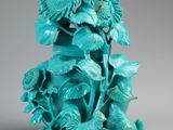 an image of a blue vase with flowers and leaves on it