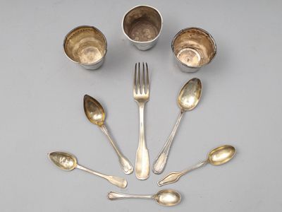 Plusieurs cuillères et tasses en argent sont disposées en cercle