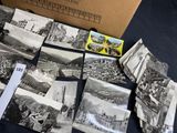 a box of old photos on a table with a bunch of them