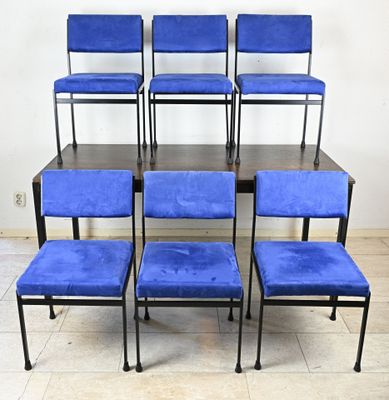 six chaises bleues posées sur une table en bois devant un mur blanc
