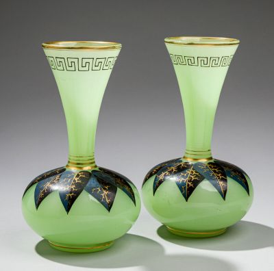 une paire de vases en verre vert ornés de motifs noirs et dorés