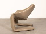 an image of a tan leather chair on a concrete floor