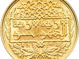 a close up of a gold coin with arabic writing on it