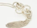 silver chain necklace with a knot and a tassel on a white background