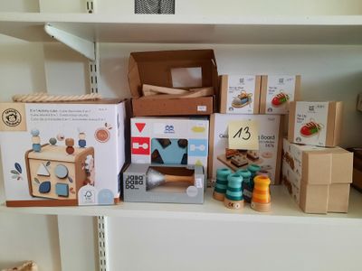 de nombreuses boîtes de jouets posées sur une étagère dans une pièce